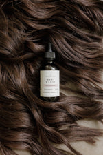 Pioneer Pam Mane Magic bottle nestled in flowing brown hair