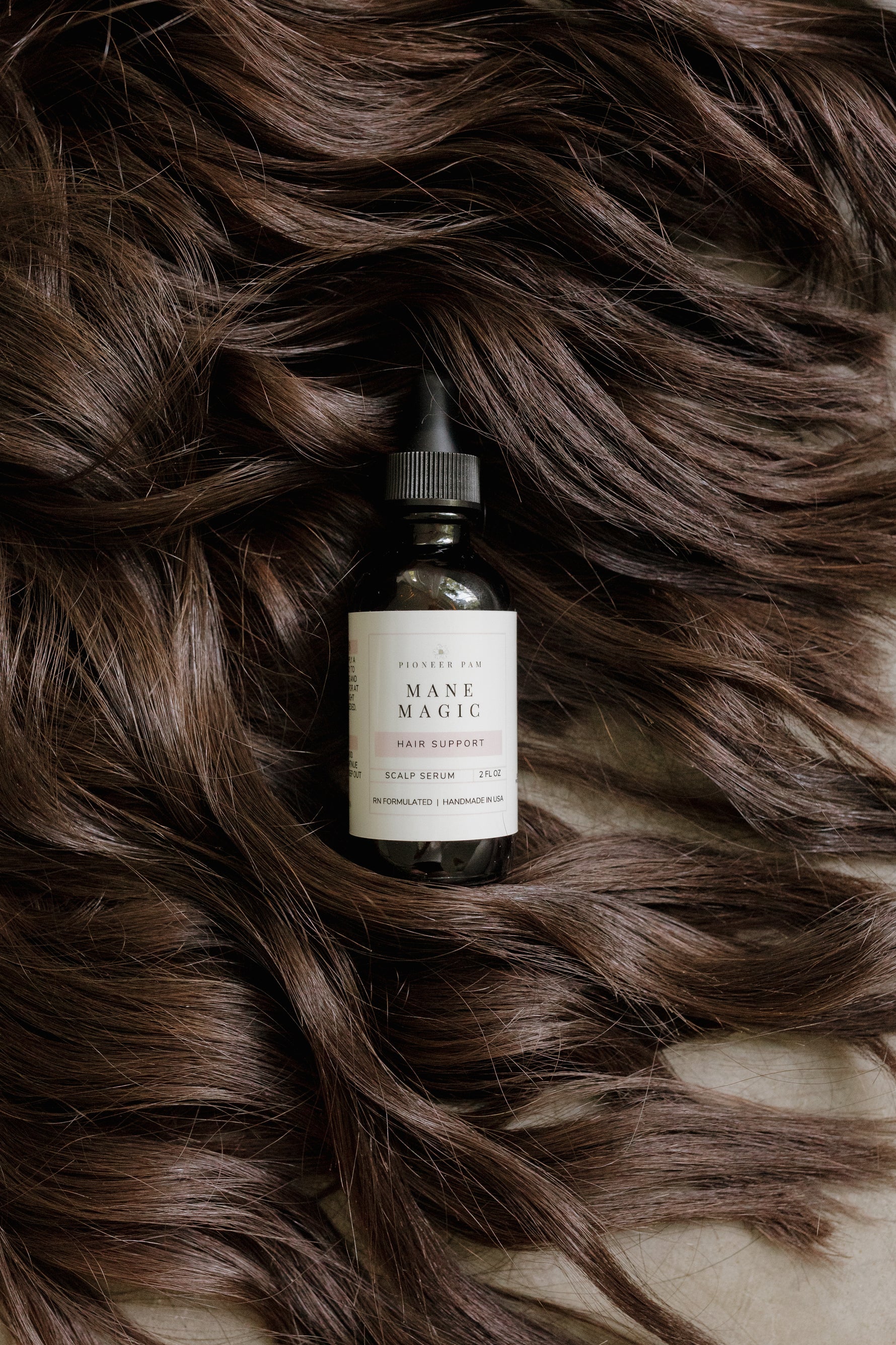 Pioneer Pam Mane Magic bottle nestled in flowing brown hair