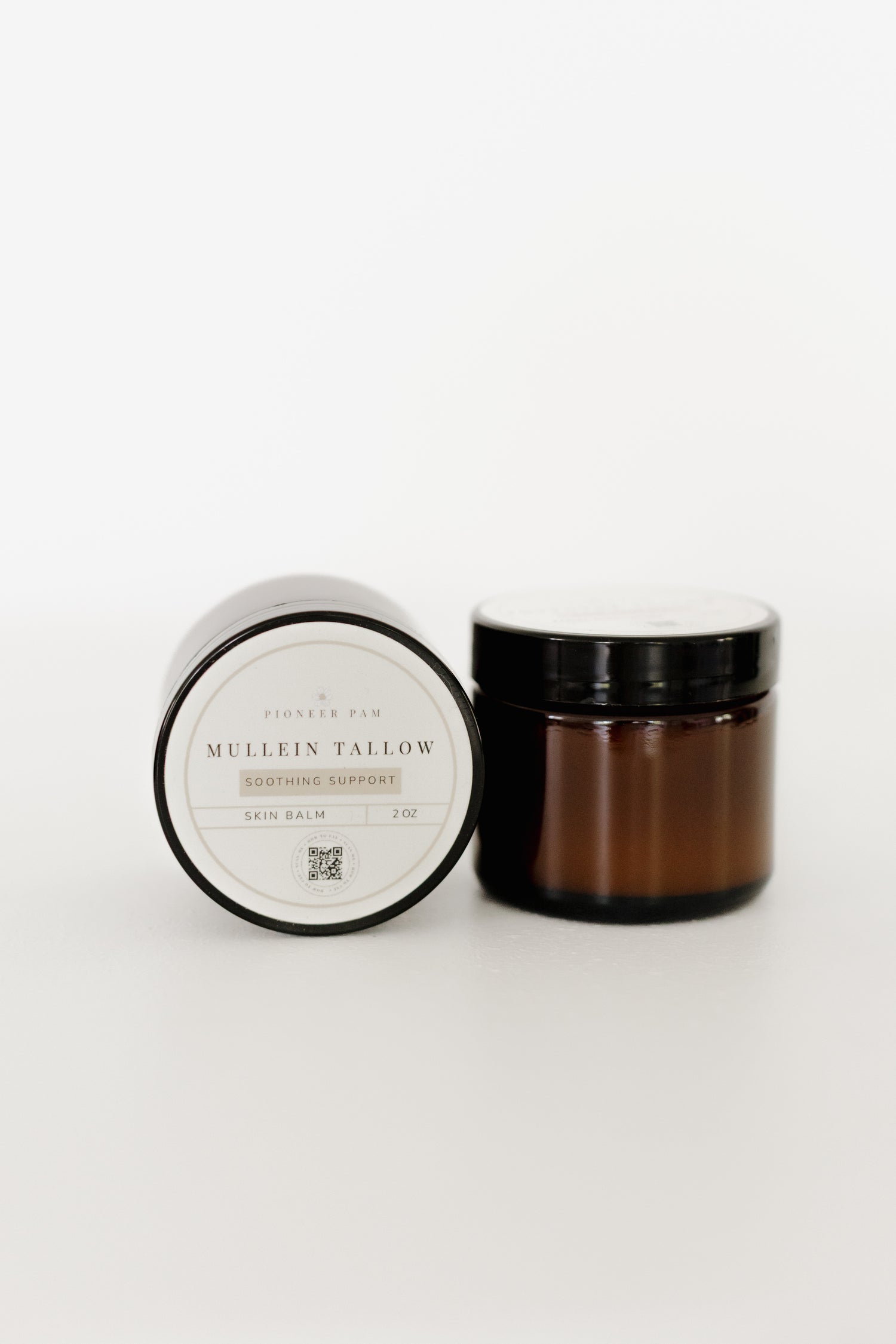 Amber glass jar of Pioneer Pam Mullein Tallow skin salve and chest rub, with lid, on a white background.