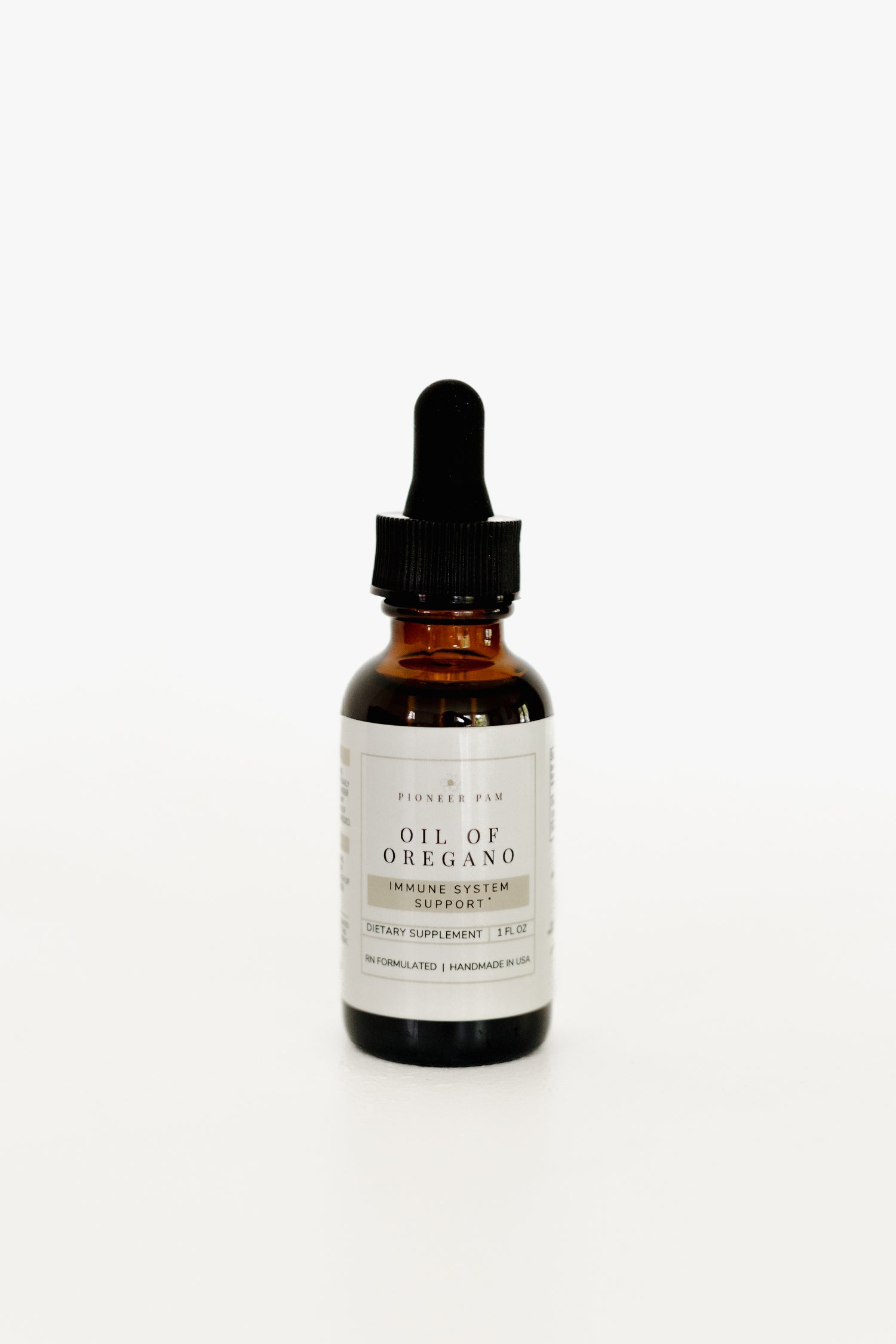 Amber glass dropper bottle of Pioneer Pam Oil of Oregano immune system support tincture on a white background.