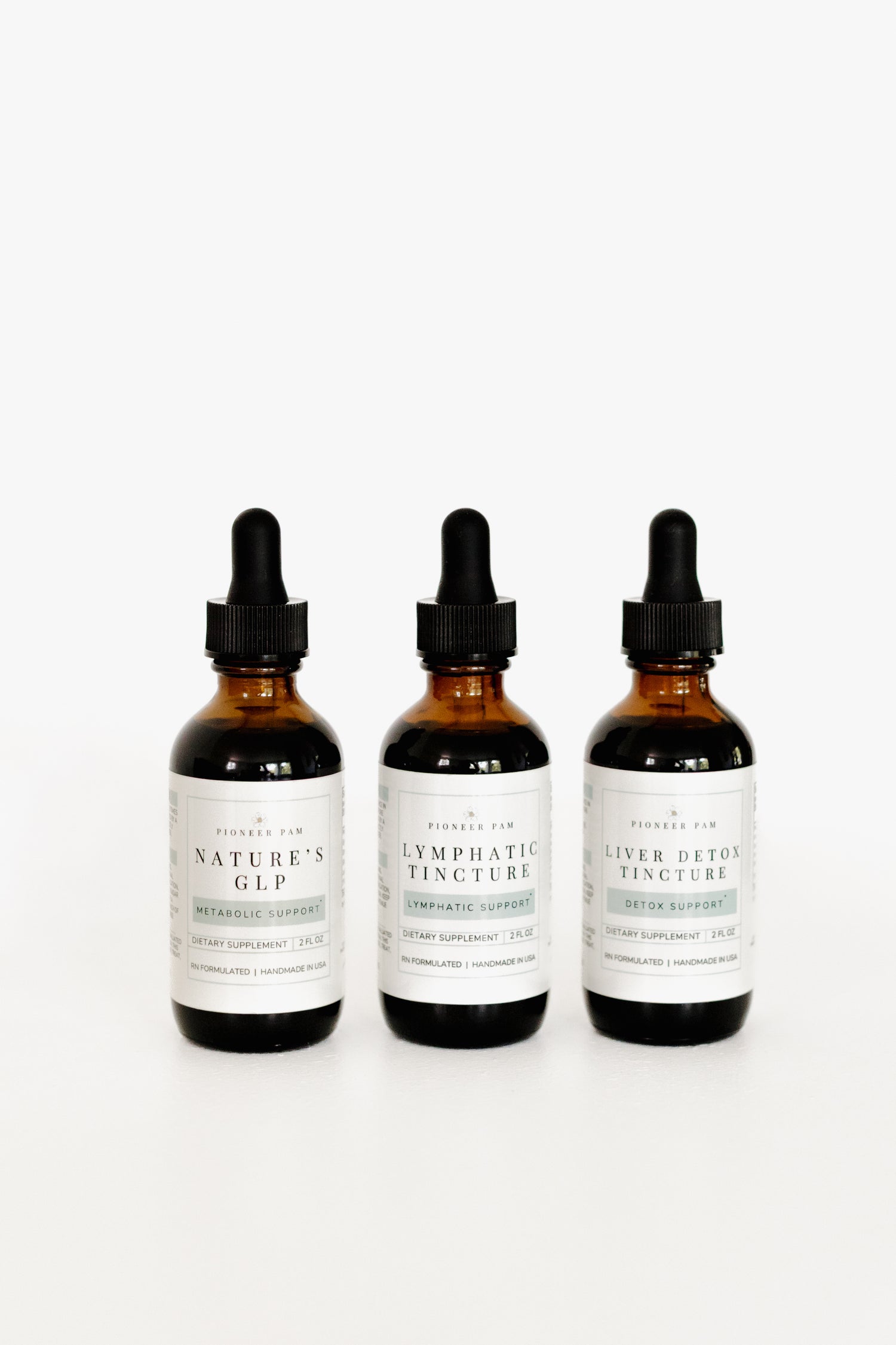 Three Pioneer Pam tincture bottles side by side: Nature's GLP, Lymphatic Tincture, and Liver Detox Tincture from the Detox & Balance Bundle